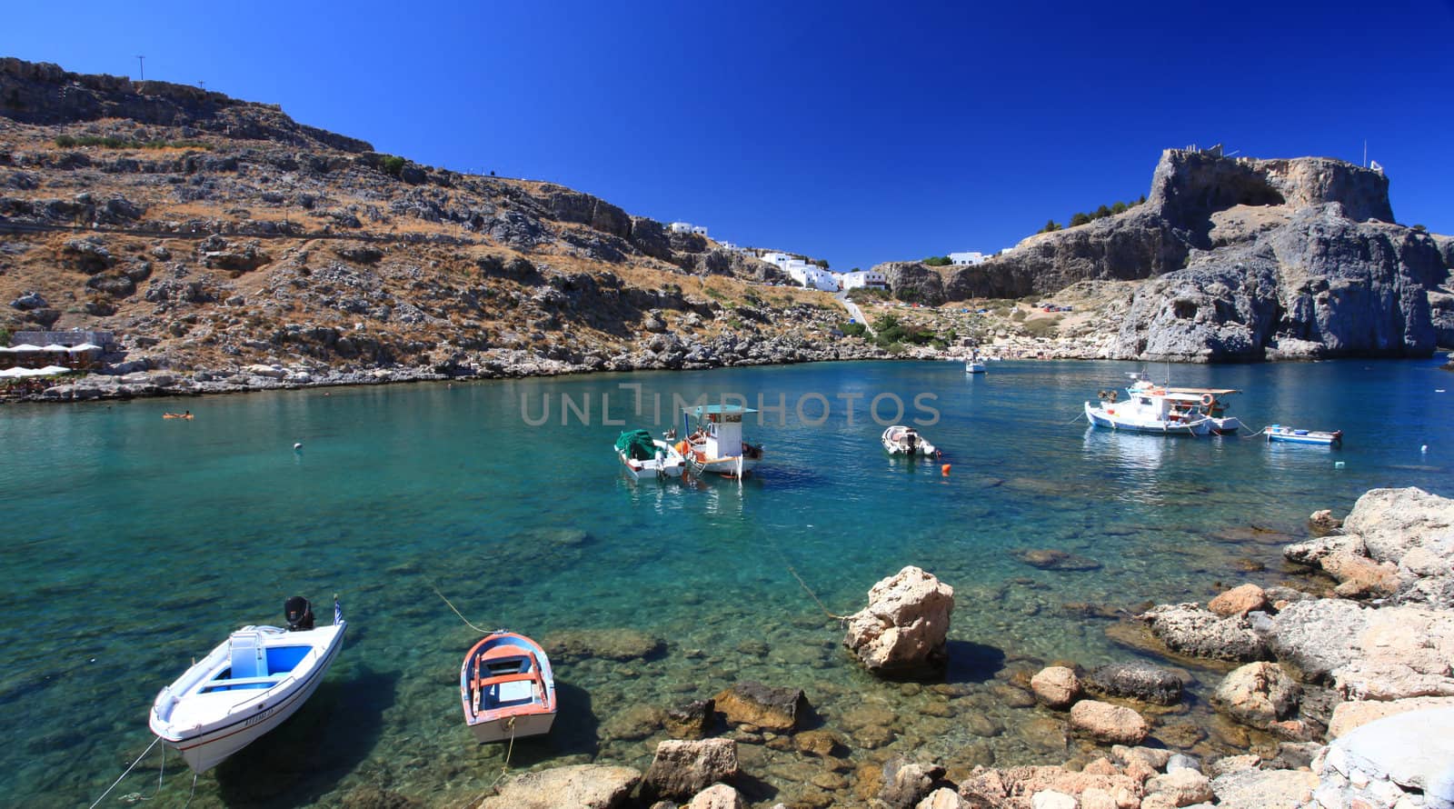 Beautiful St Pauls Bay shadowed by the temple and castle ruins at Lindos 