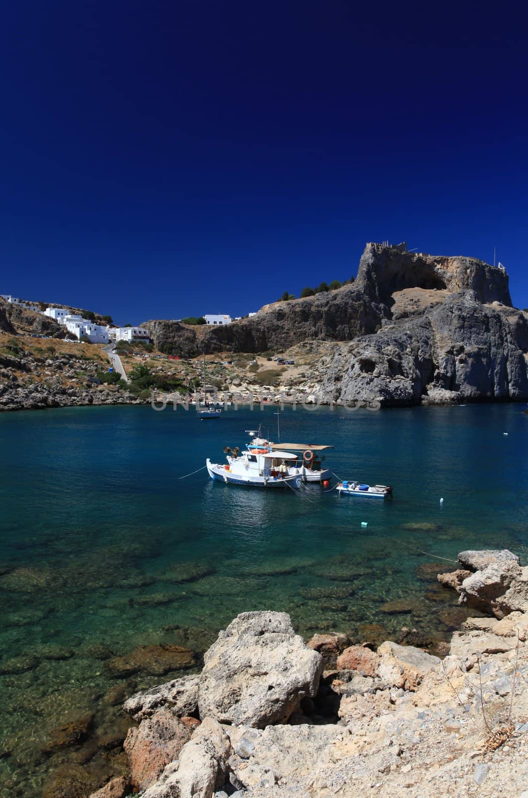 Beautiful St Pauls Bay shadowed by the temple and castle ruins at Lindos 