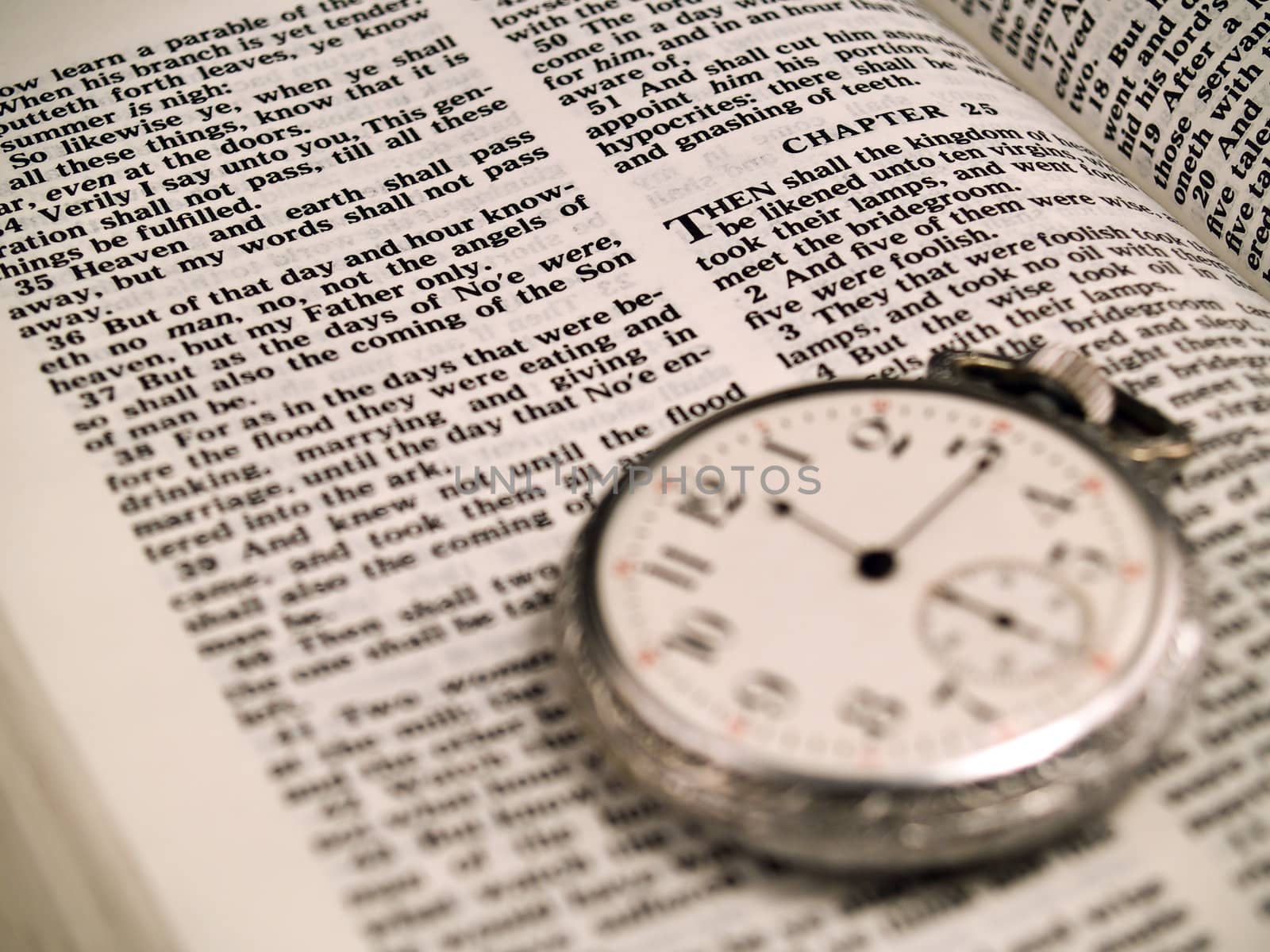 The Bible opened to Matthew 24: 36 with a Pocketwatch - warm color tone  "No man knows the day or hour"