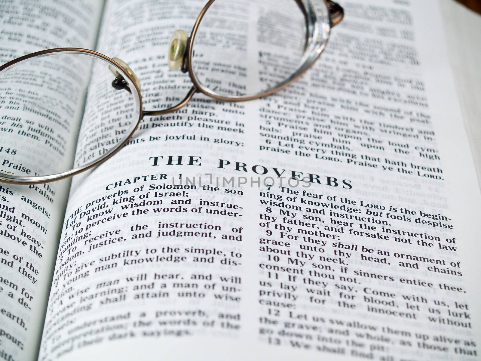 The Bible opened to the Book of Proverbs with Glasses