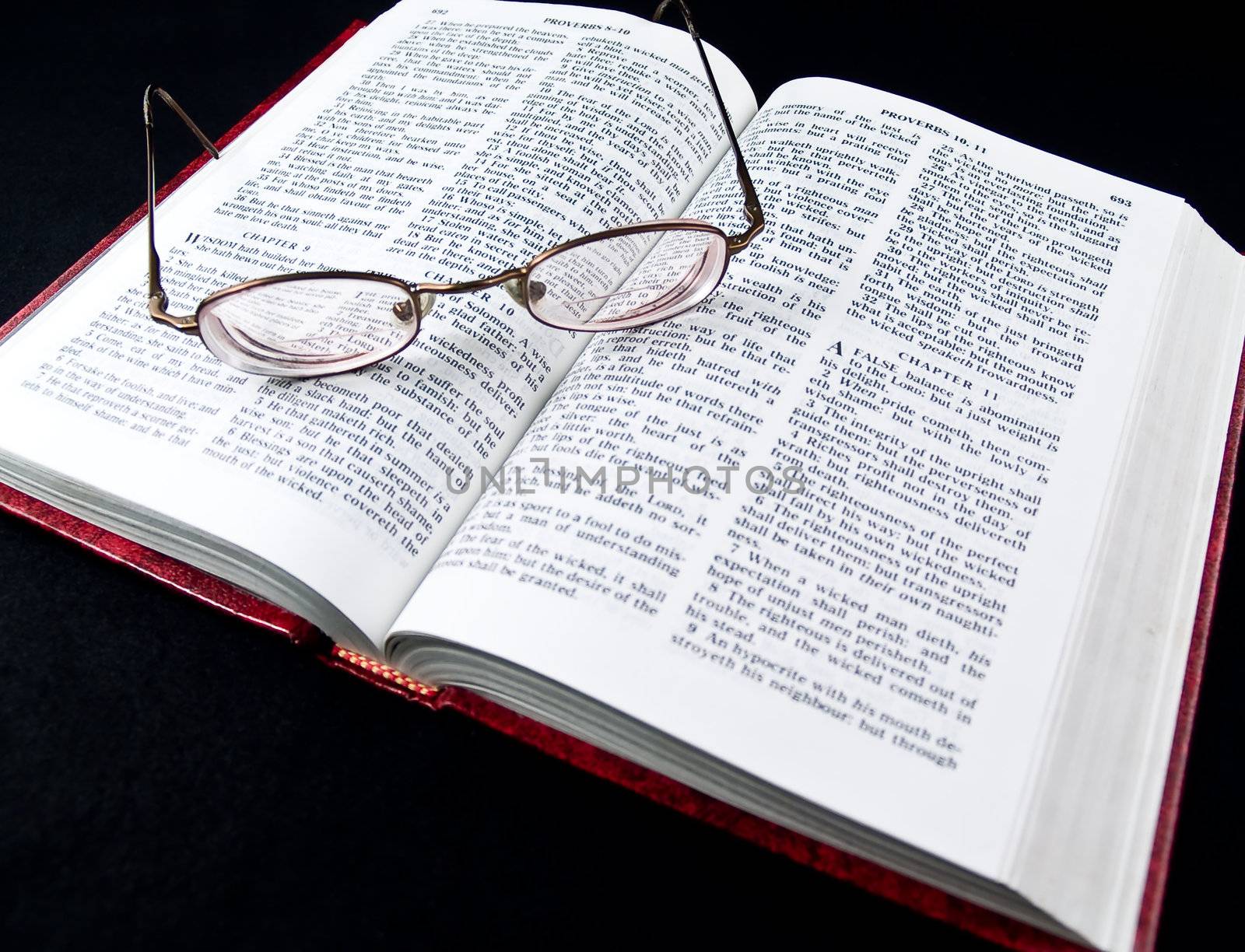 The Bible opened to the Book of Proverbs with Glasses