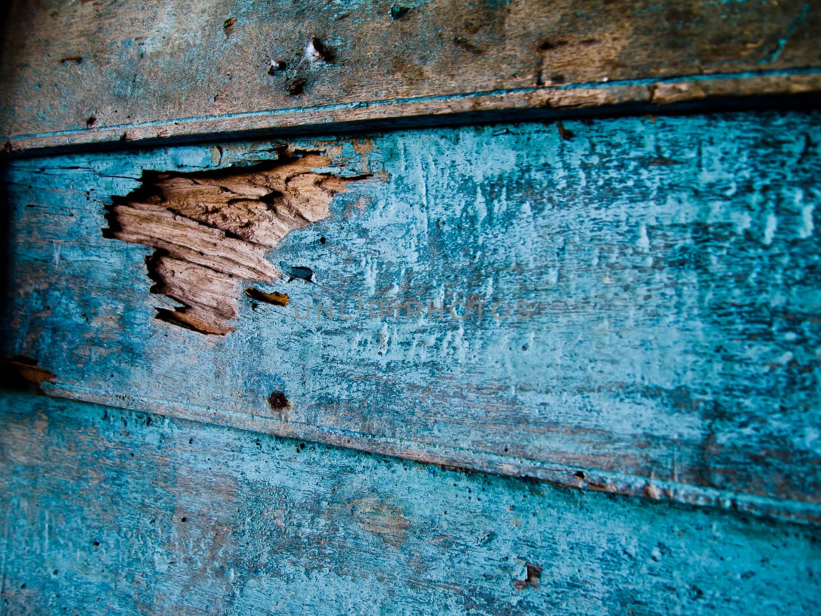 Cracked point on blue wood wall by gjeerawut