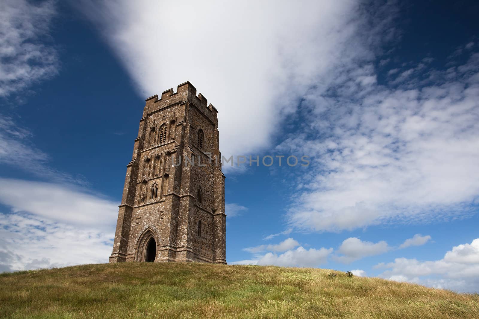 Tourists exploring the ruins of St. Michael's Tower at the top of glastonbury tor in sommerest england