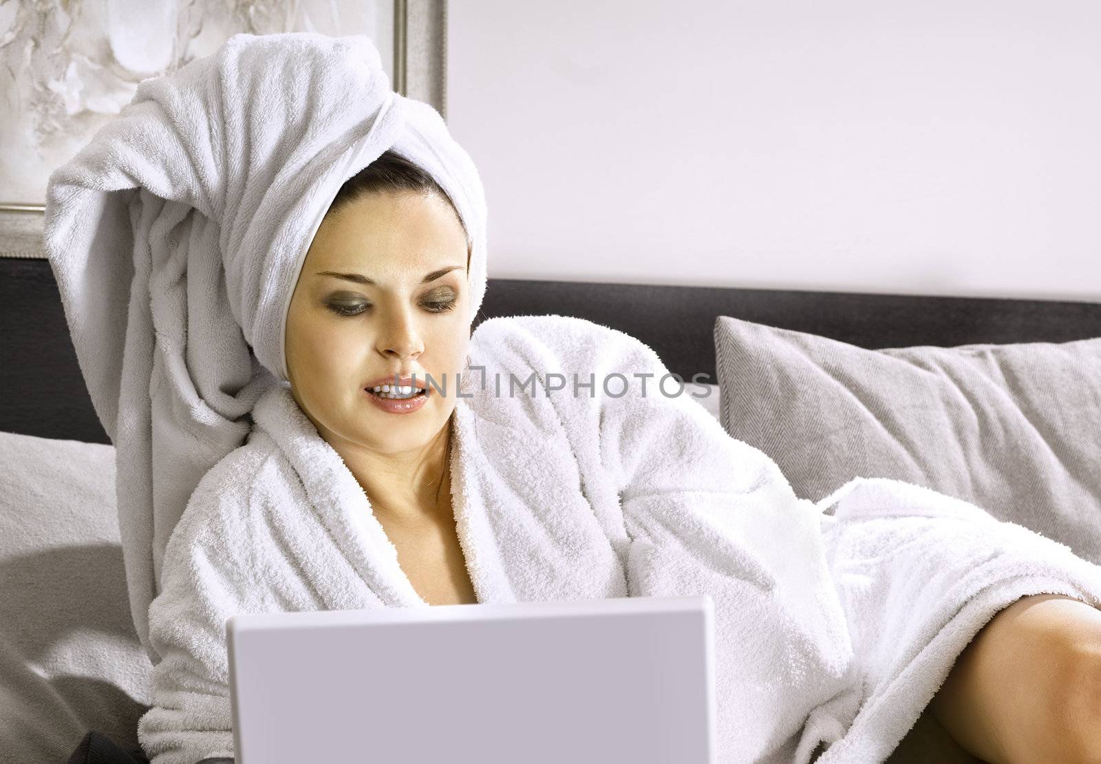 Lady with laptop on bed by ssuaphoto