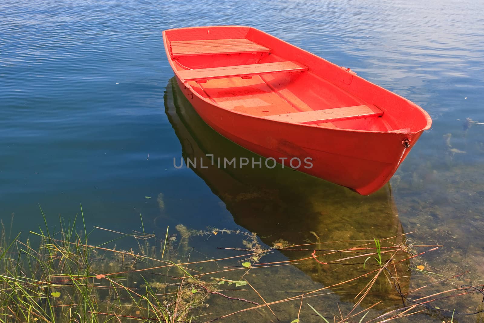 Red rowing boat on lake