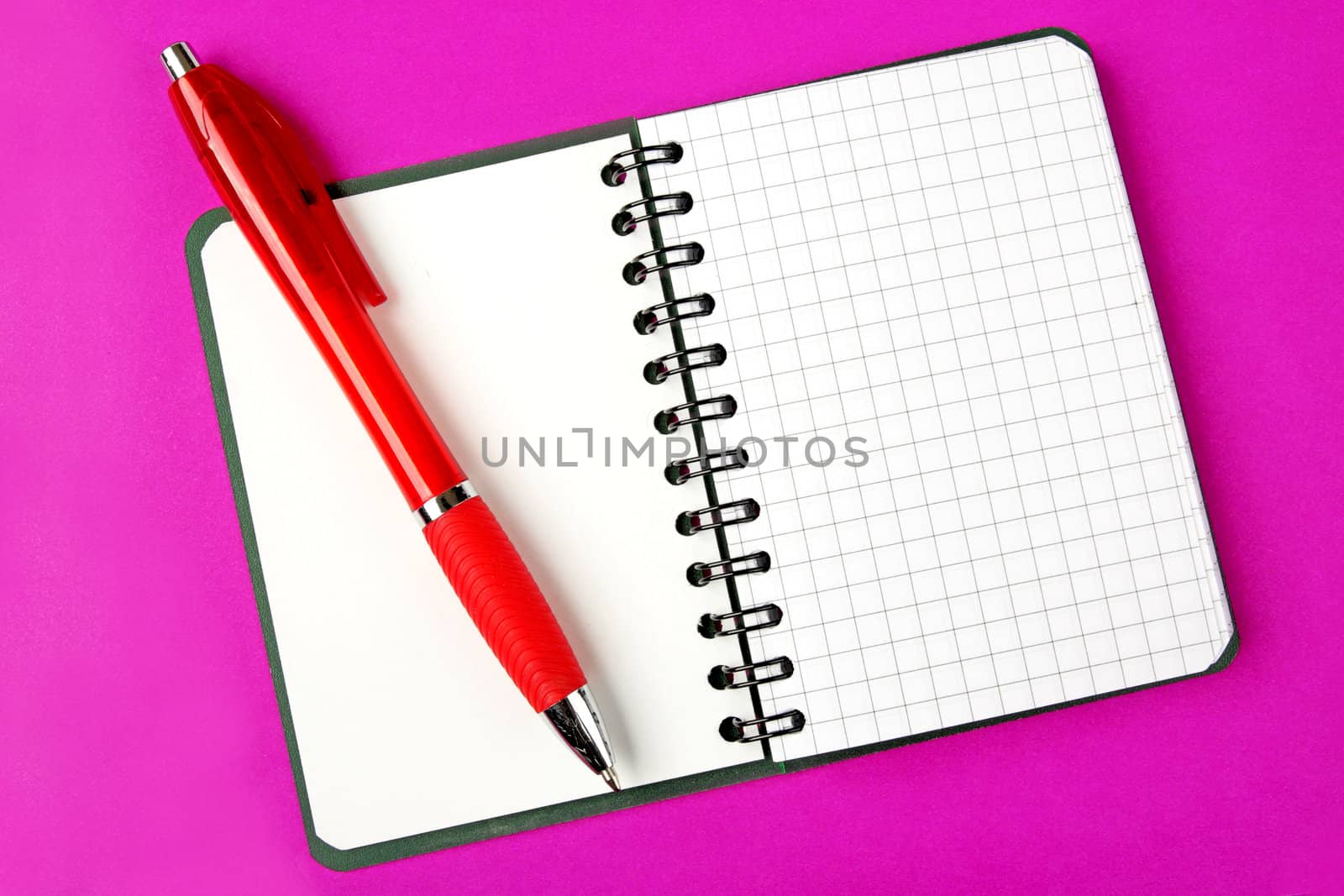 Opened notebook squared pagewith red pen over it on purple background 