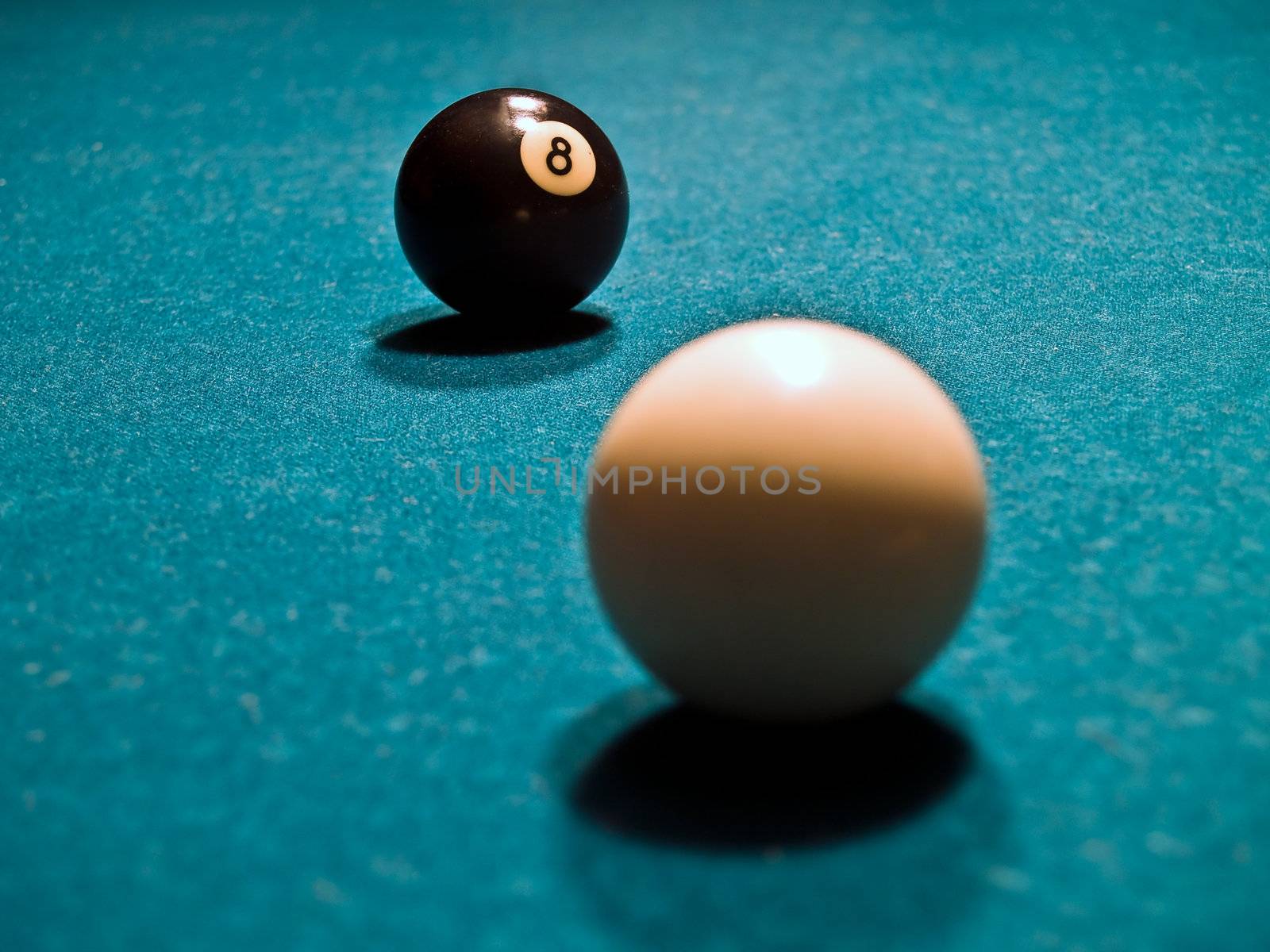 An Eight Ball and Cue Ball on a Green Billiards Table by Frankljunior