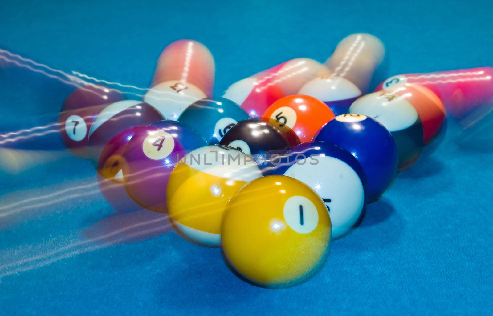 Billiards balls with motion on a green pool table