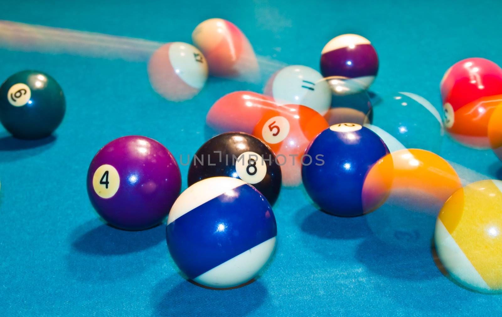 Billiards balls with motion on a green pool table