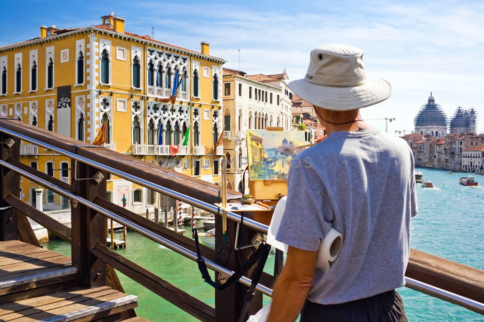 An artist painting a beautiful picture on a bridge in Venice, Italy