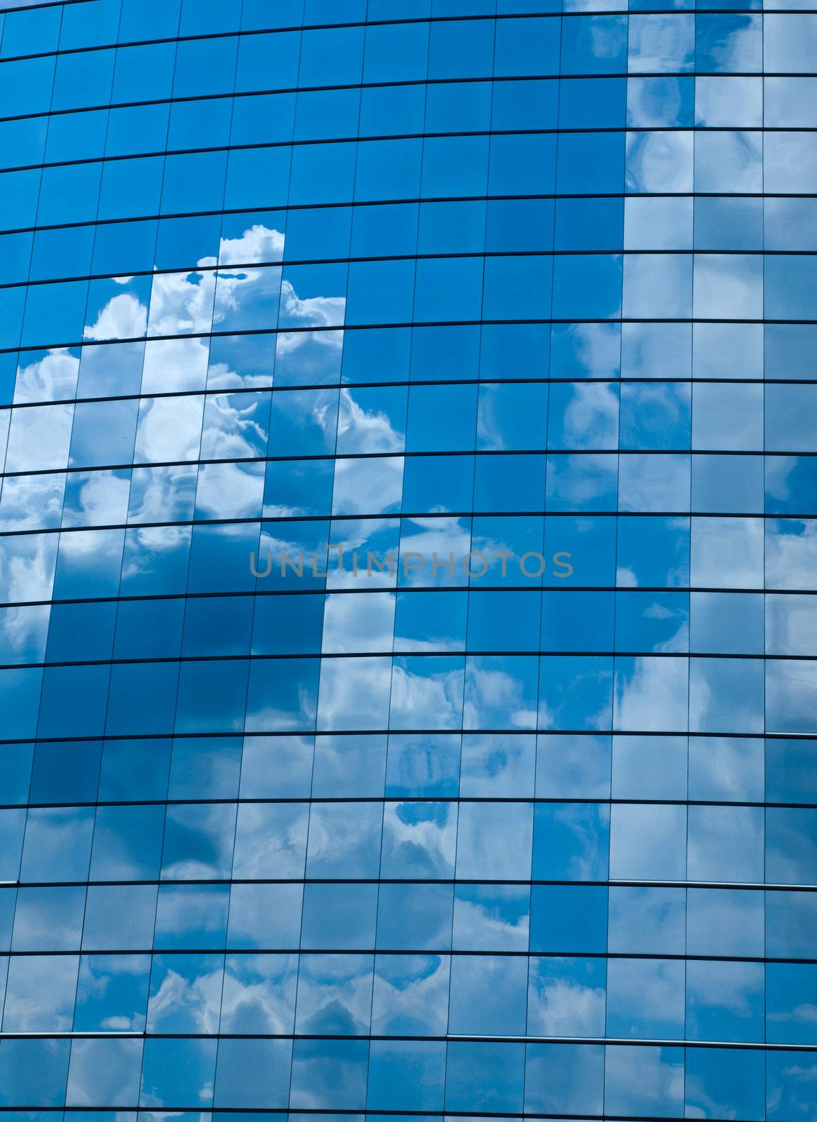 Clouds reflected in windows of modern office building by Frankljunior