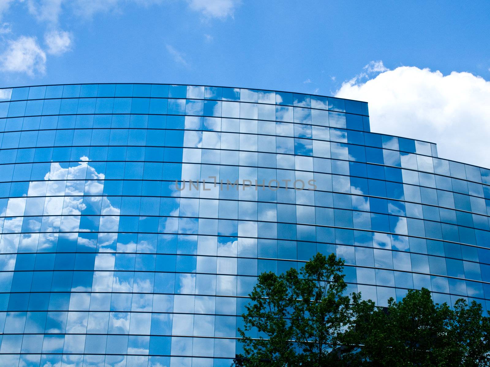 Clouds reflected in windows of modern office building by Frankljunior