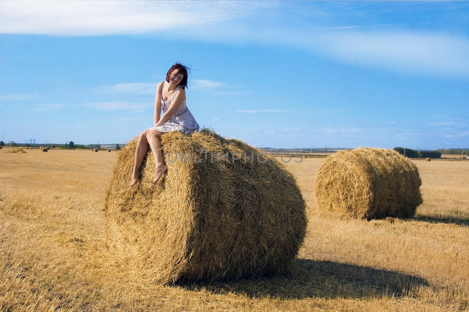 woman on a haystack in a field outside the city