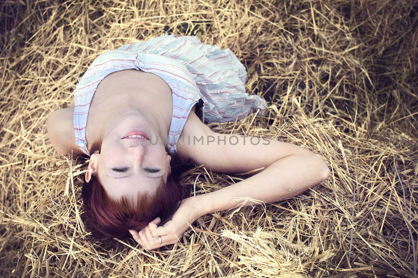 woman on a hay in a field outside the city