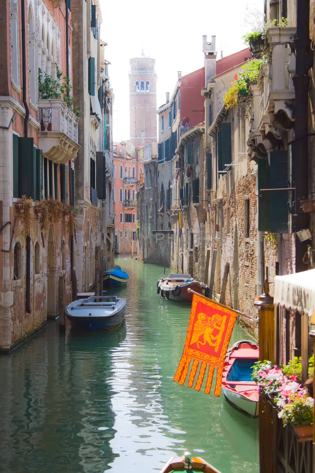 Beautiful canal and traditional venetian flag, Venice, Italy