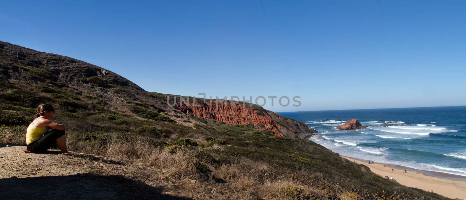 View of a young woman watching a beautiful landscape on the Sagres region.