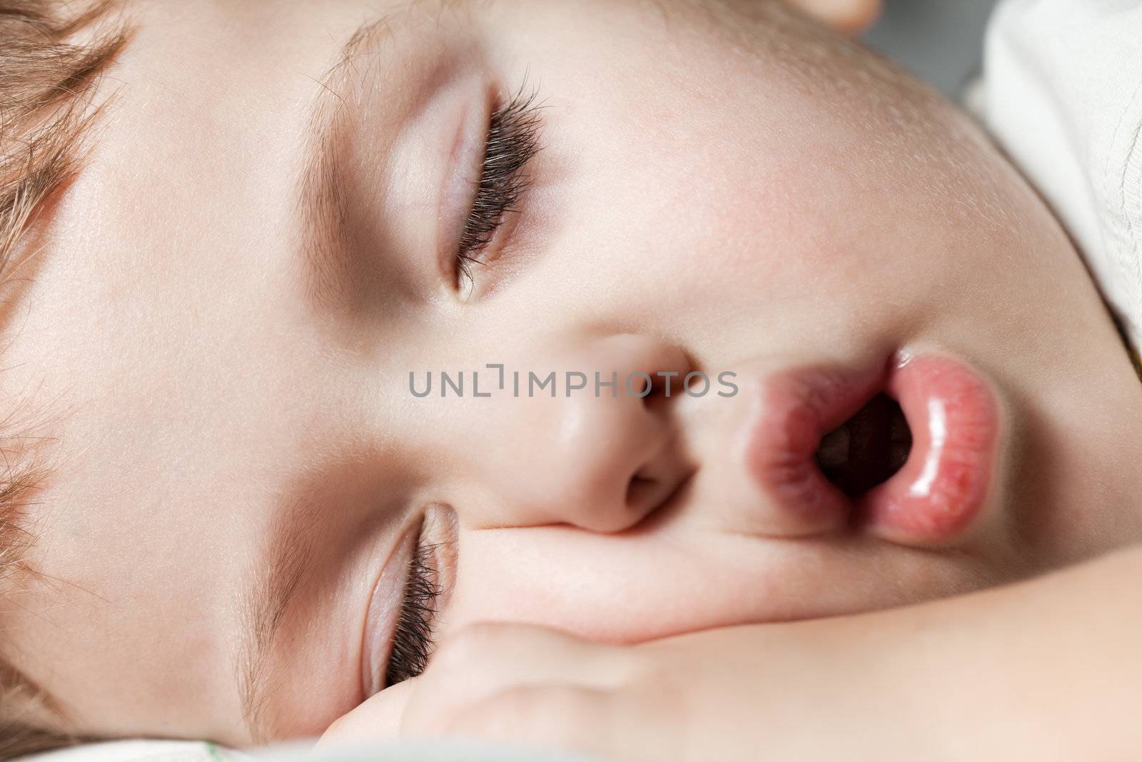 Funny sleeping little cute human child boy closed eyes face