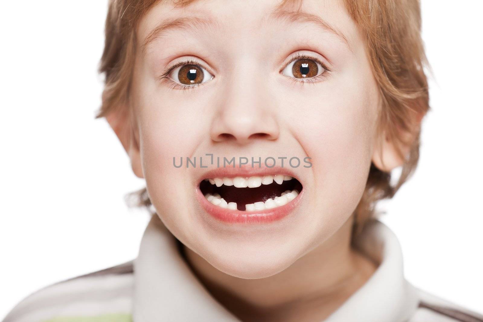 Little smiling child boy showing his first baby milk or temporary tooth fall out in open mouth