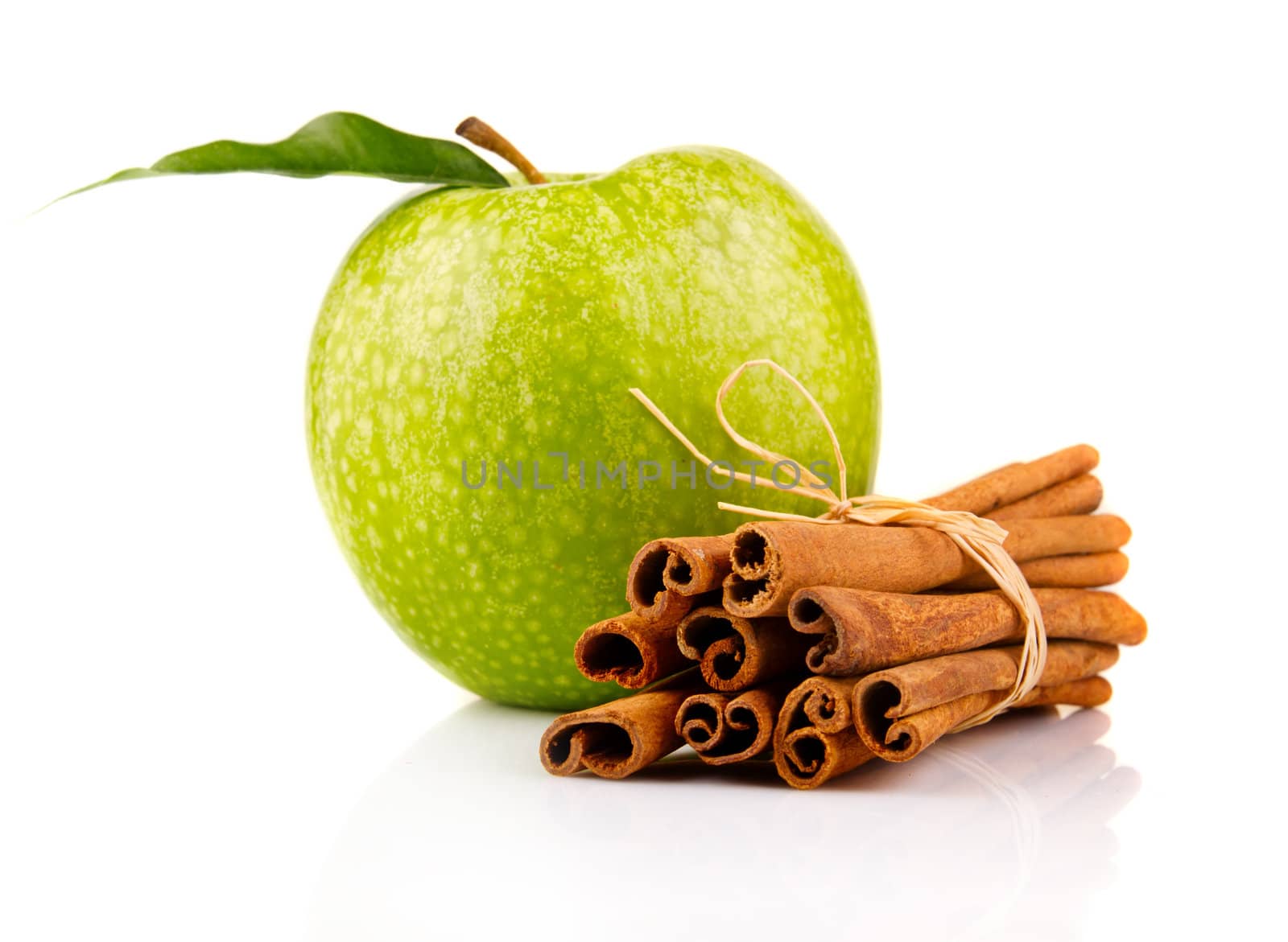 Ripe green apple with cinnamon sticks isolated on white background 