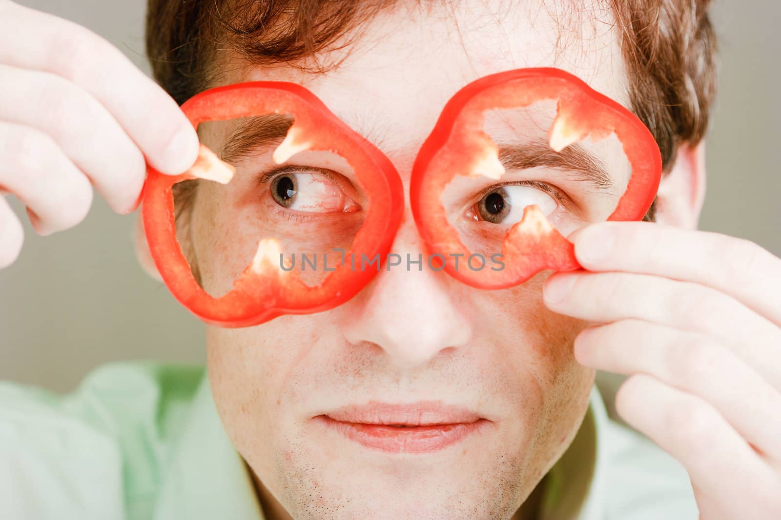 Portrait of a man with slices of sweet pepper