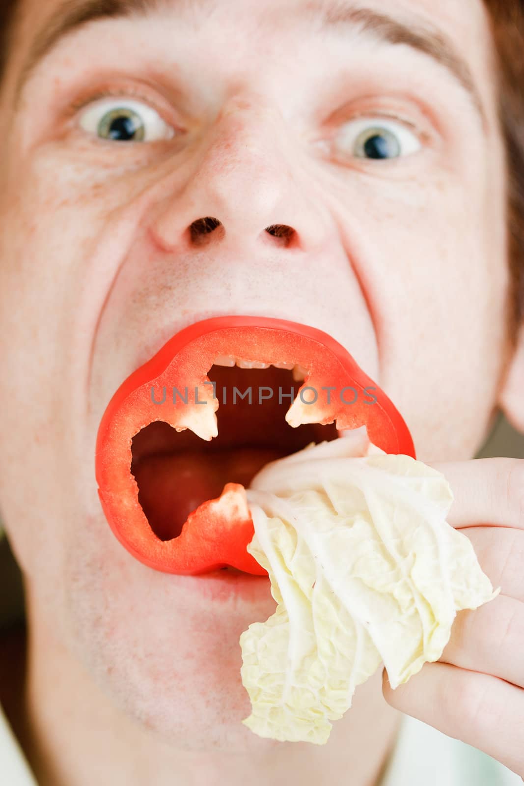 Portrait of a man with slices of sweet pepper