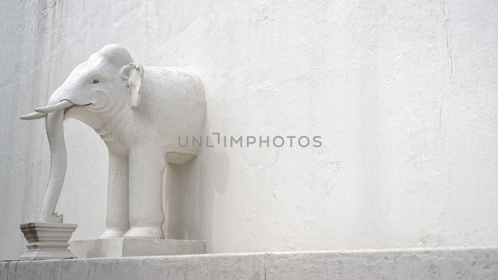 The half of elephant in the white wall of asian temple