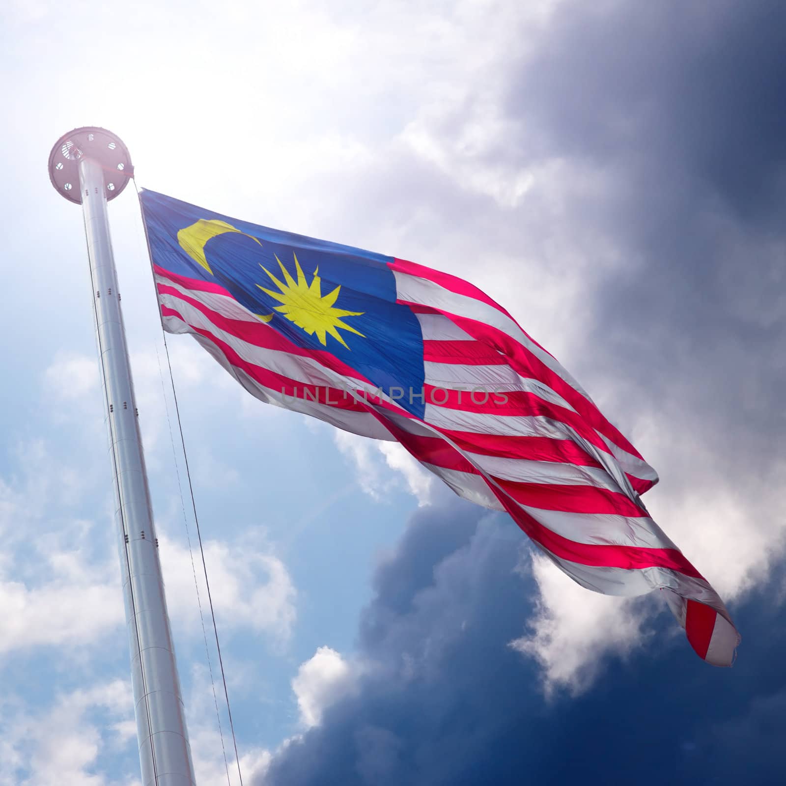 Waving flag of Malaysia on the cloudy sky background