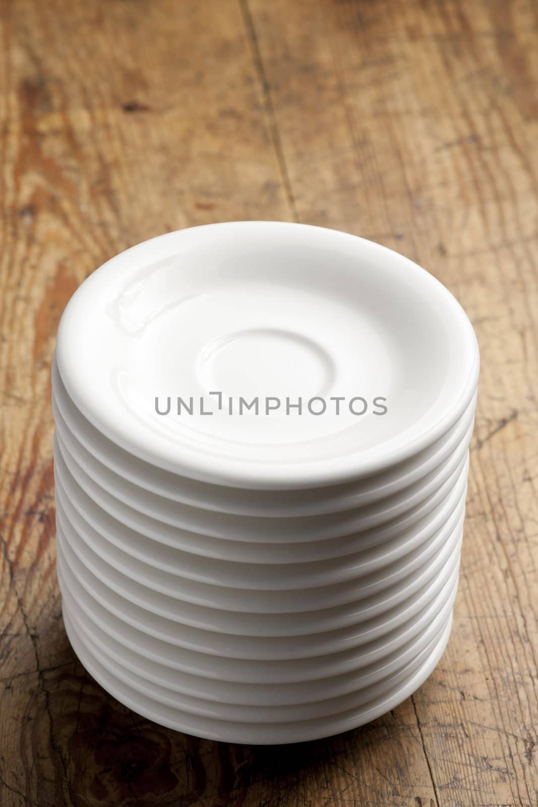 Stack of white porcelain coffee saucers.