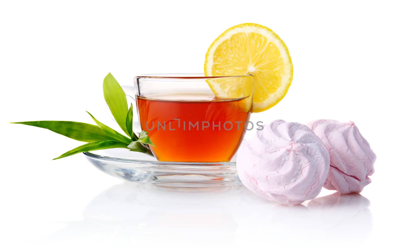 Cup of black tea with lemon, green leaves and marshmallow isolated on white background