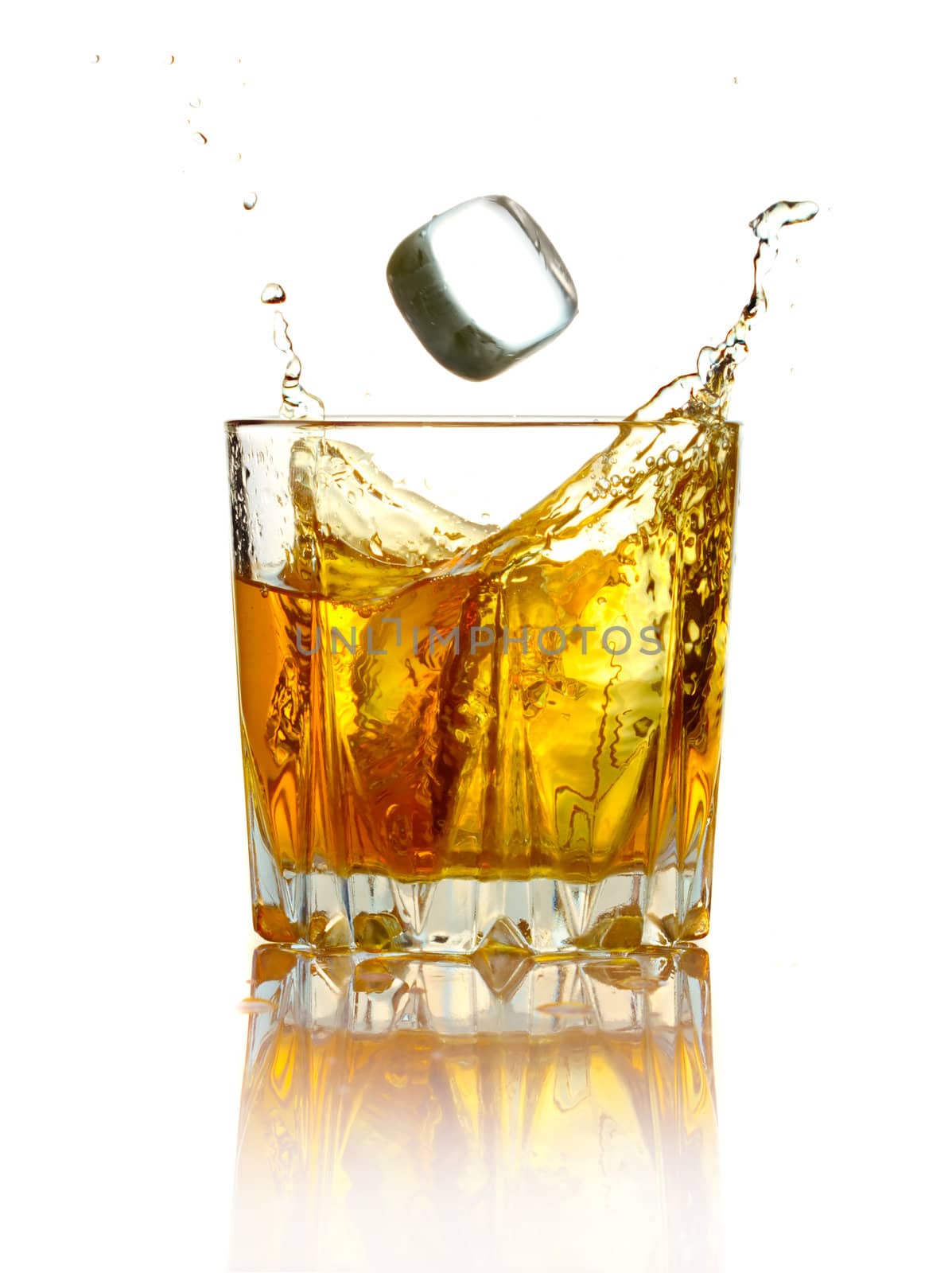 Splash in glass of whiskey and ice isolated on white background 