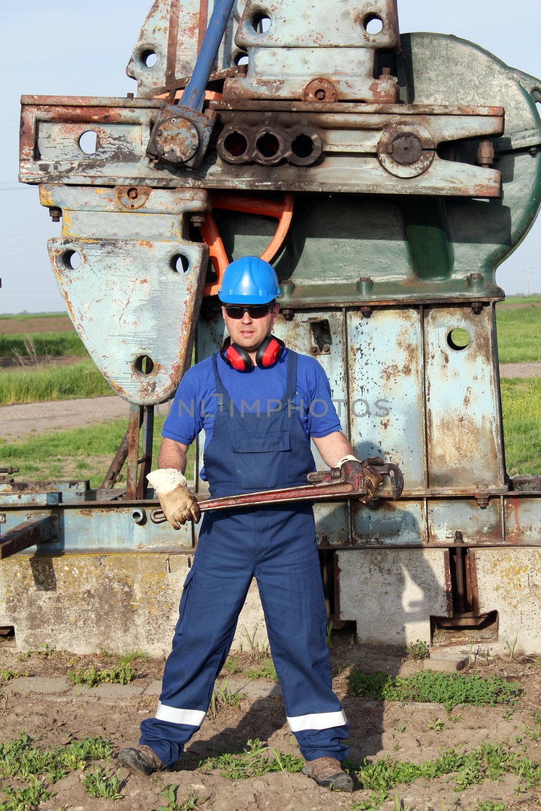 oil worker with pipe wrench by goce