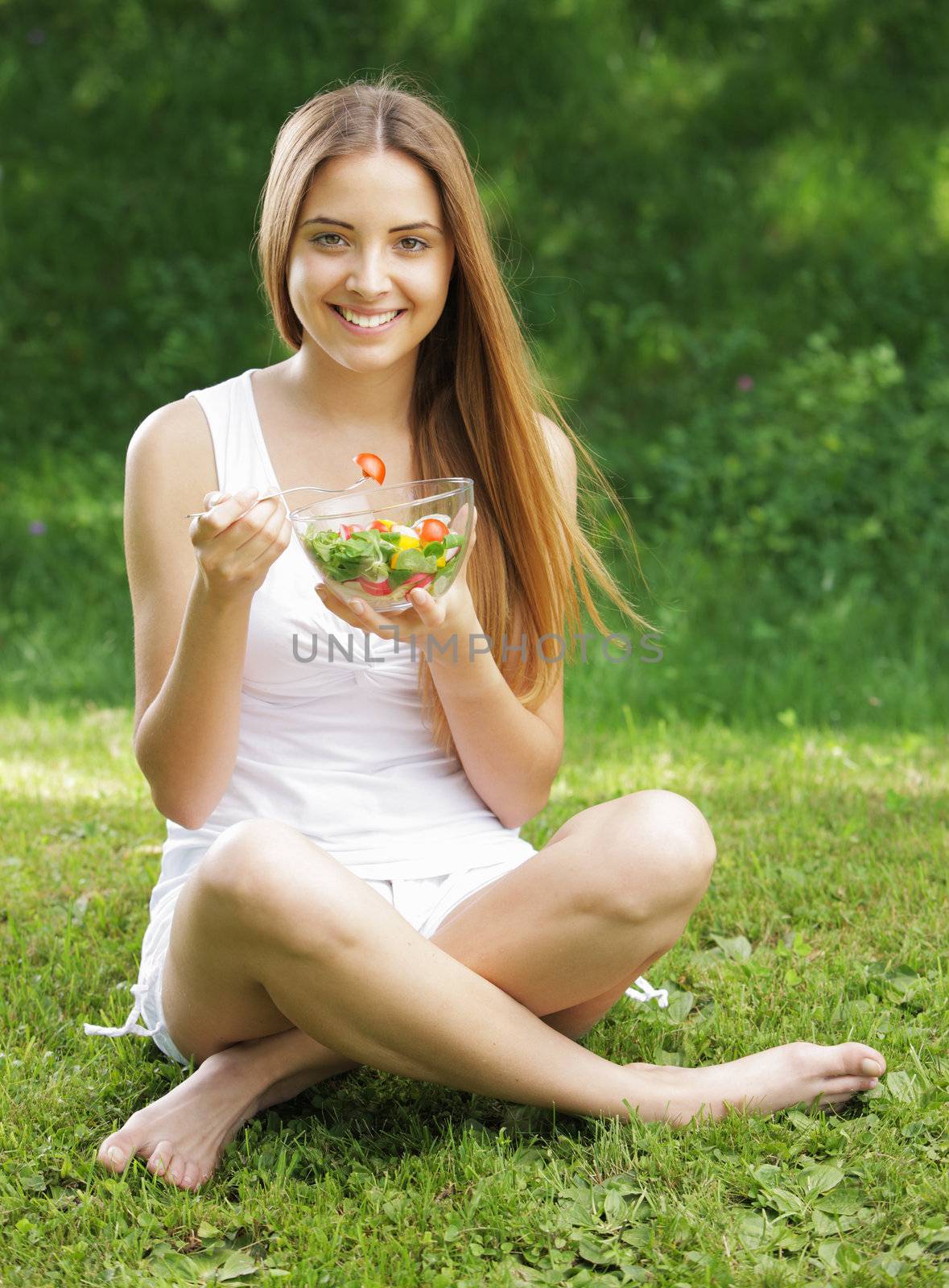 Portrait of young happy woman eating salad