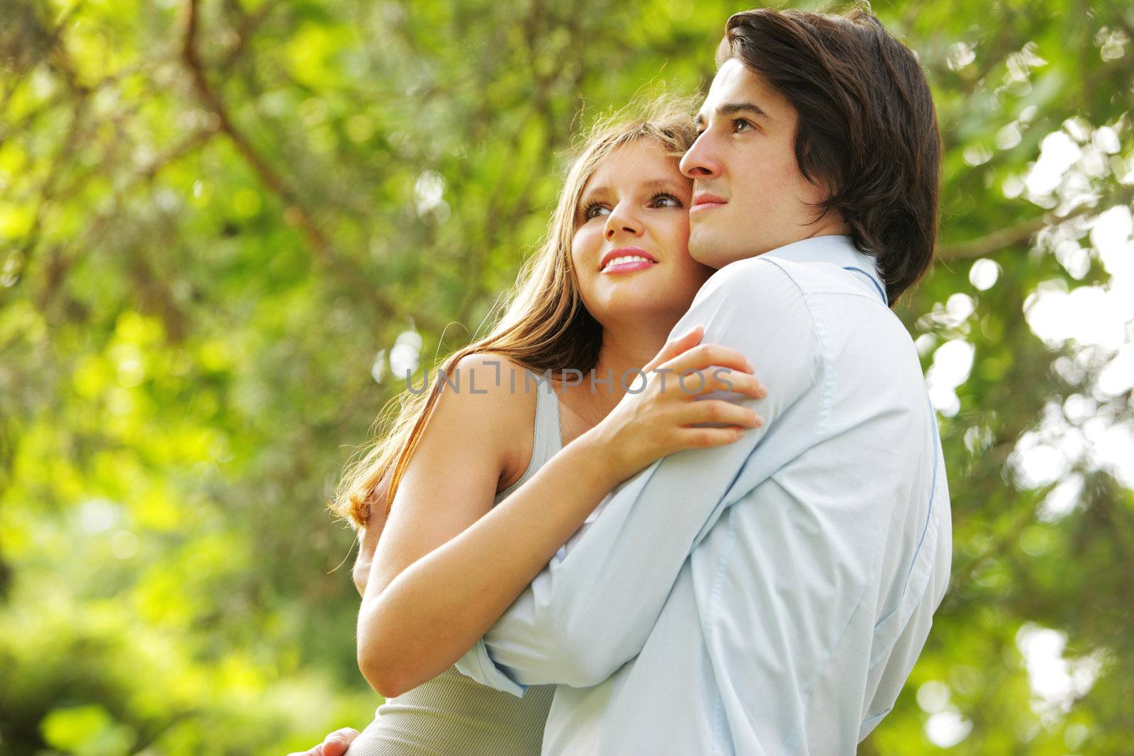 a romantic couple in the park watching the horizon, imagining the future