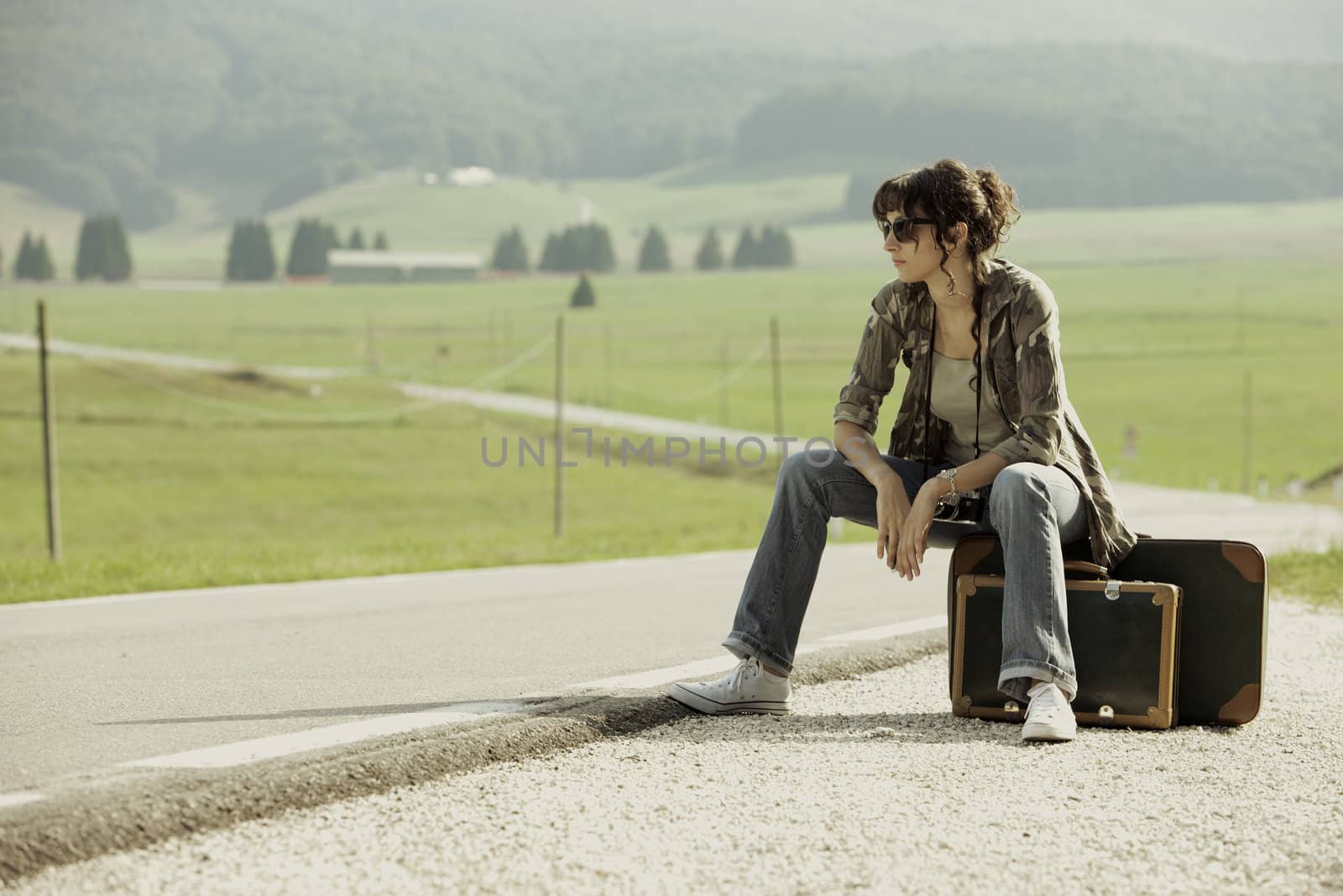 girl in the road sit atop vintage suitcase