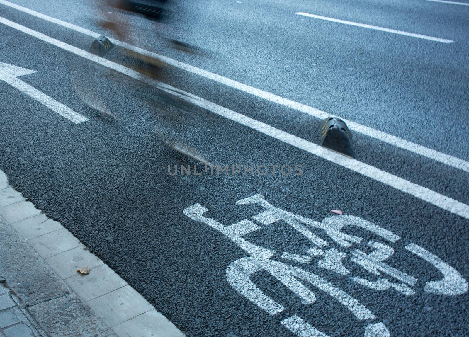 Speedy ciclyst on urban cycle lane.