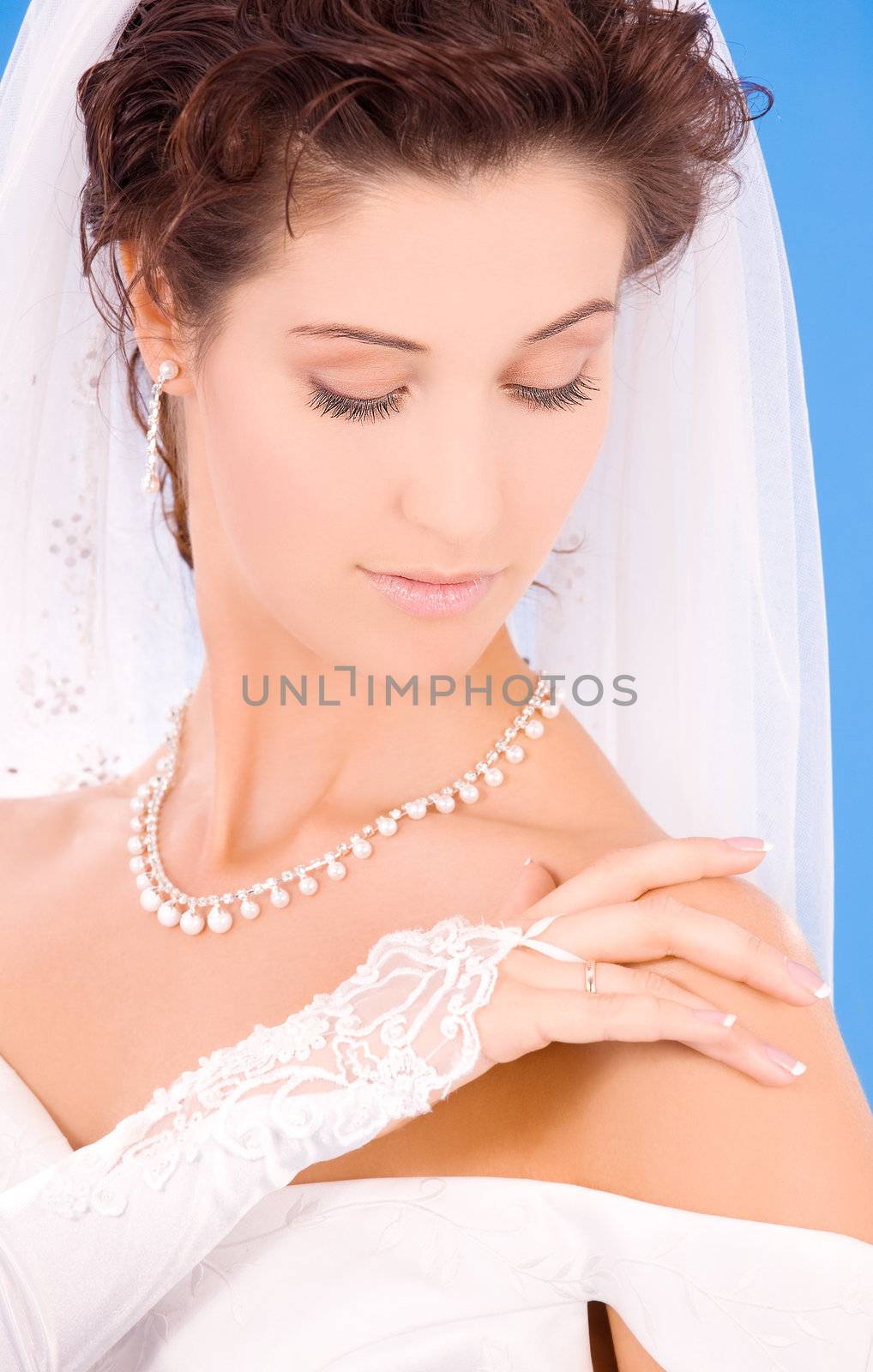 happy bride with her wedding ring over blue