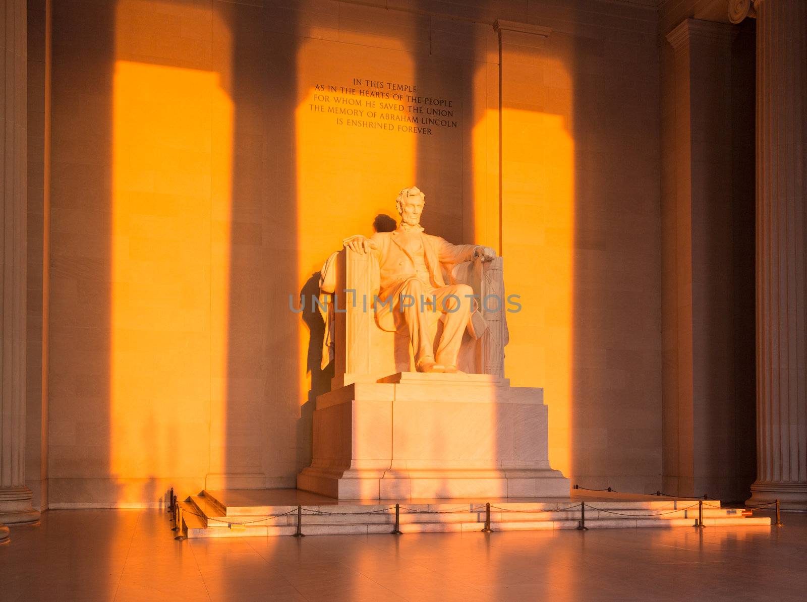 Rising sunrise at dawn lights statue of President Lincoln in memorial in Washington DC