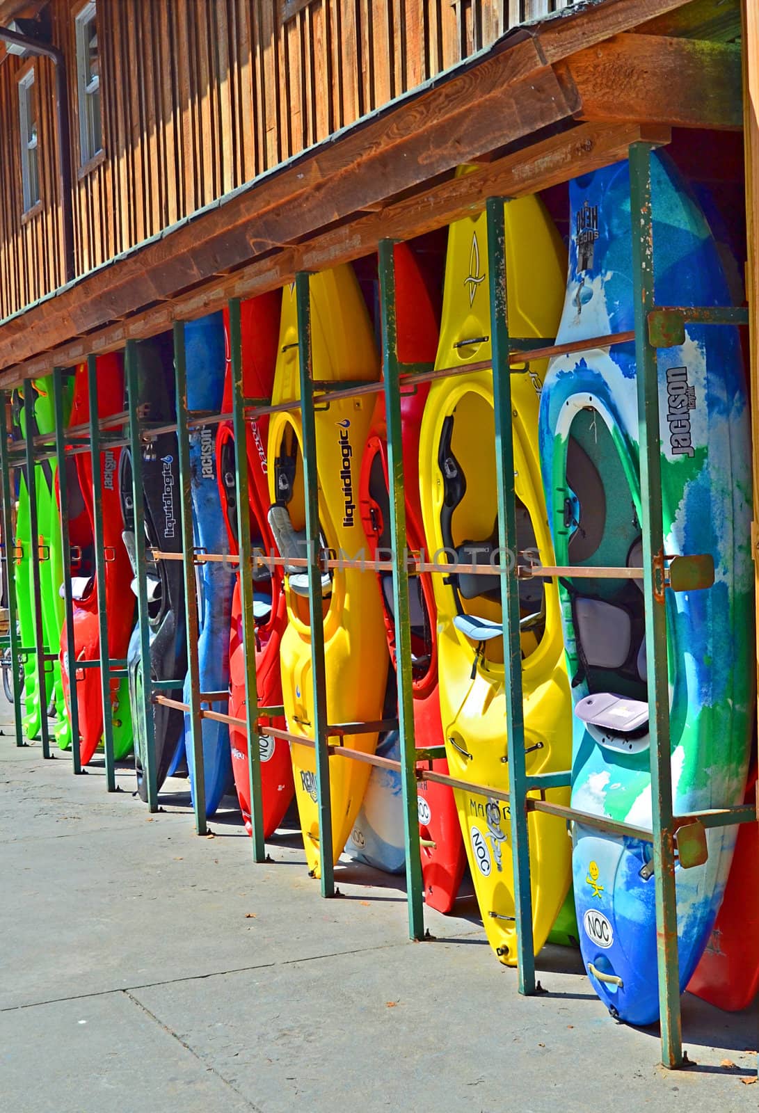Kayaks on the side of an outdoor center building waiting to be rented.