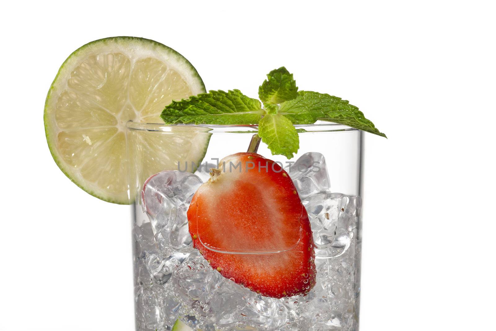 cropped image of a glass with ice cubes strawberry slice and lem by kozzi