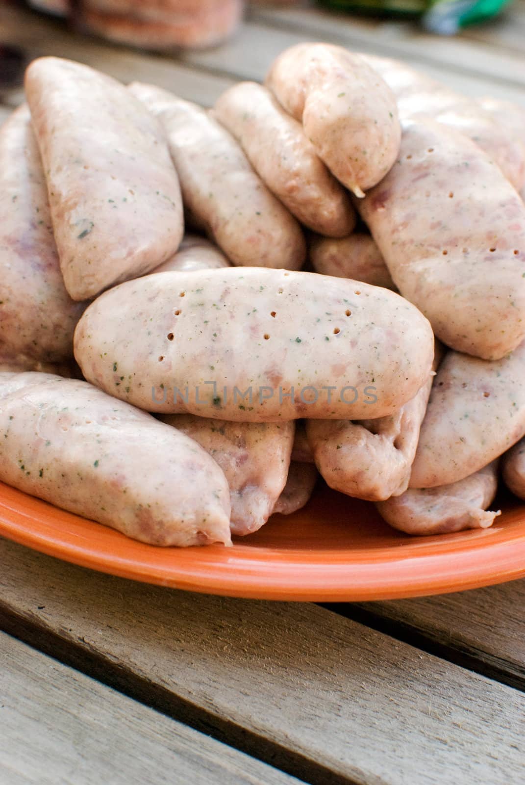 sausages in an orange plate over wooden table