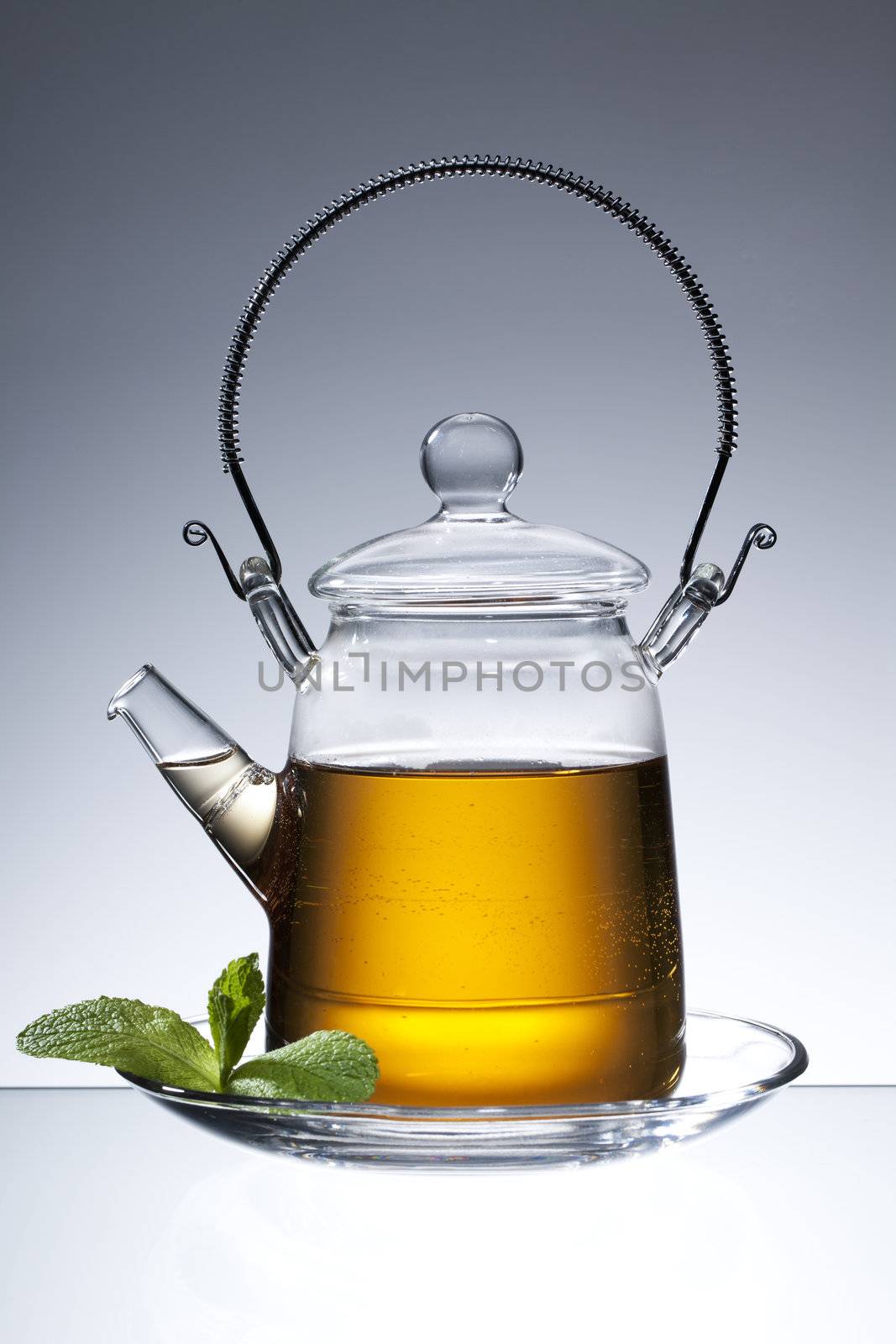 tea pitcher on a saucer with mint leaf