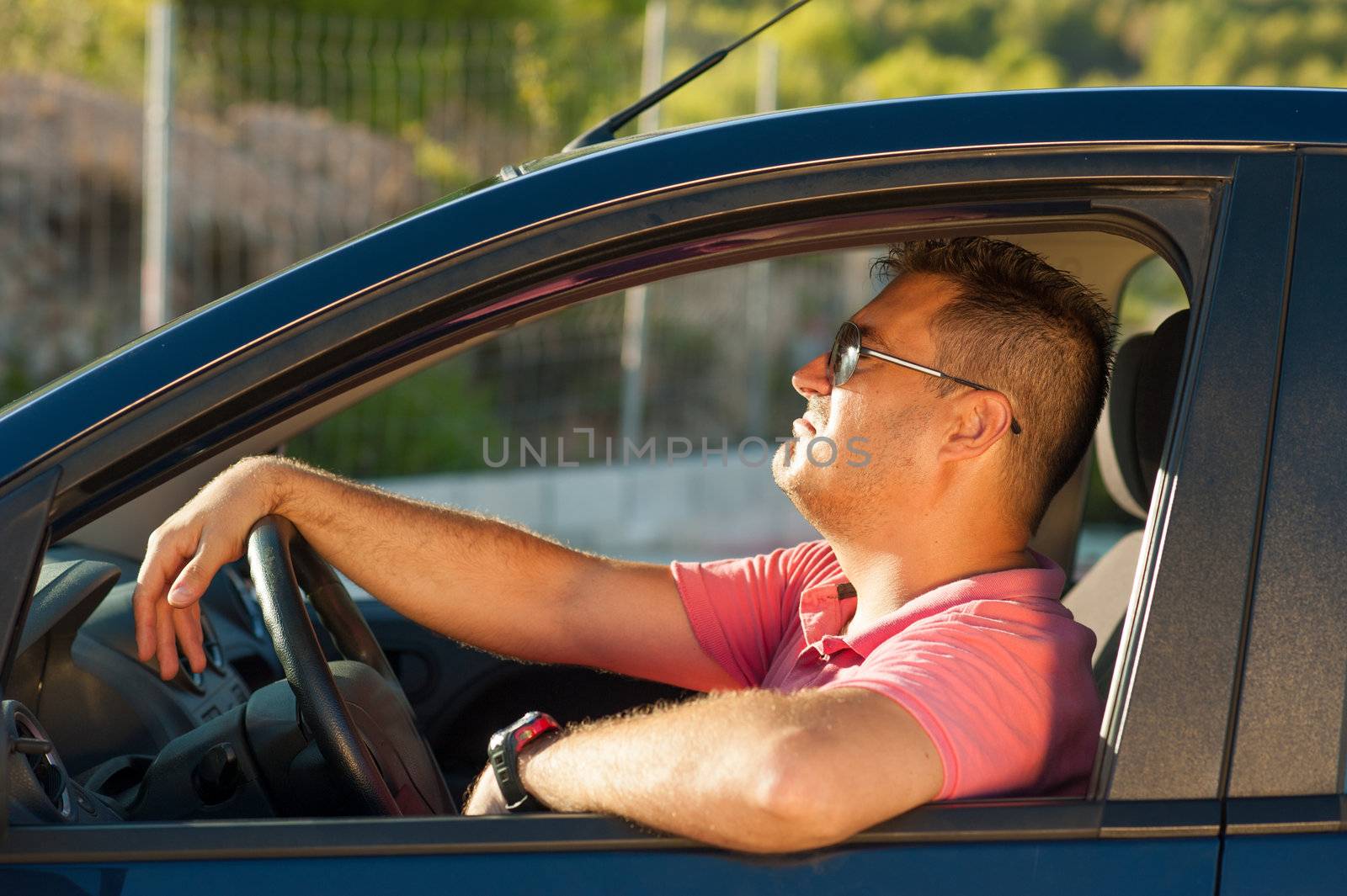 Latin guy inside his car trying to look cool