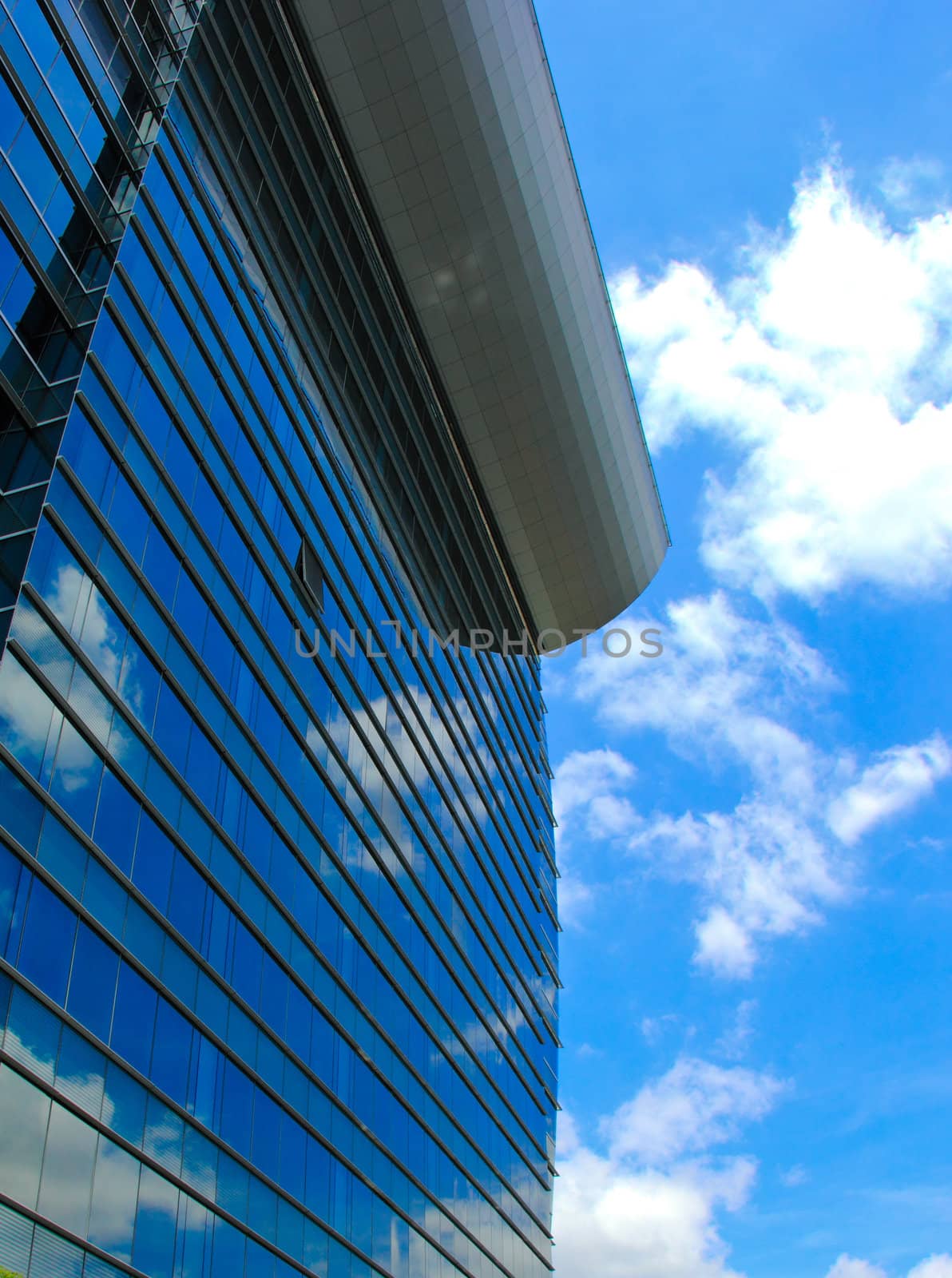 Modern office building and blue sky reflection  by nuchylee