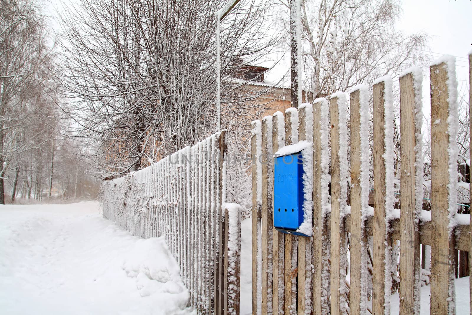 blue mailbox on wooden fence