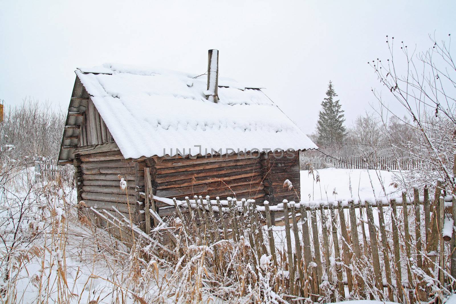 old rural wooden house amongst snow