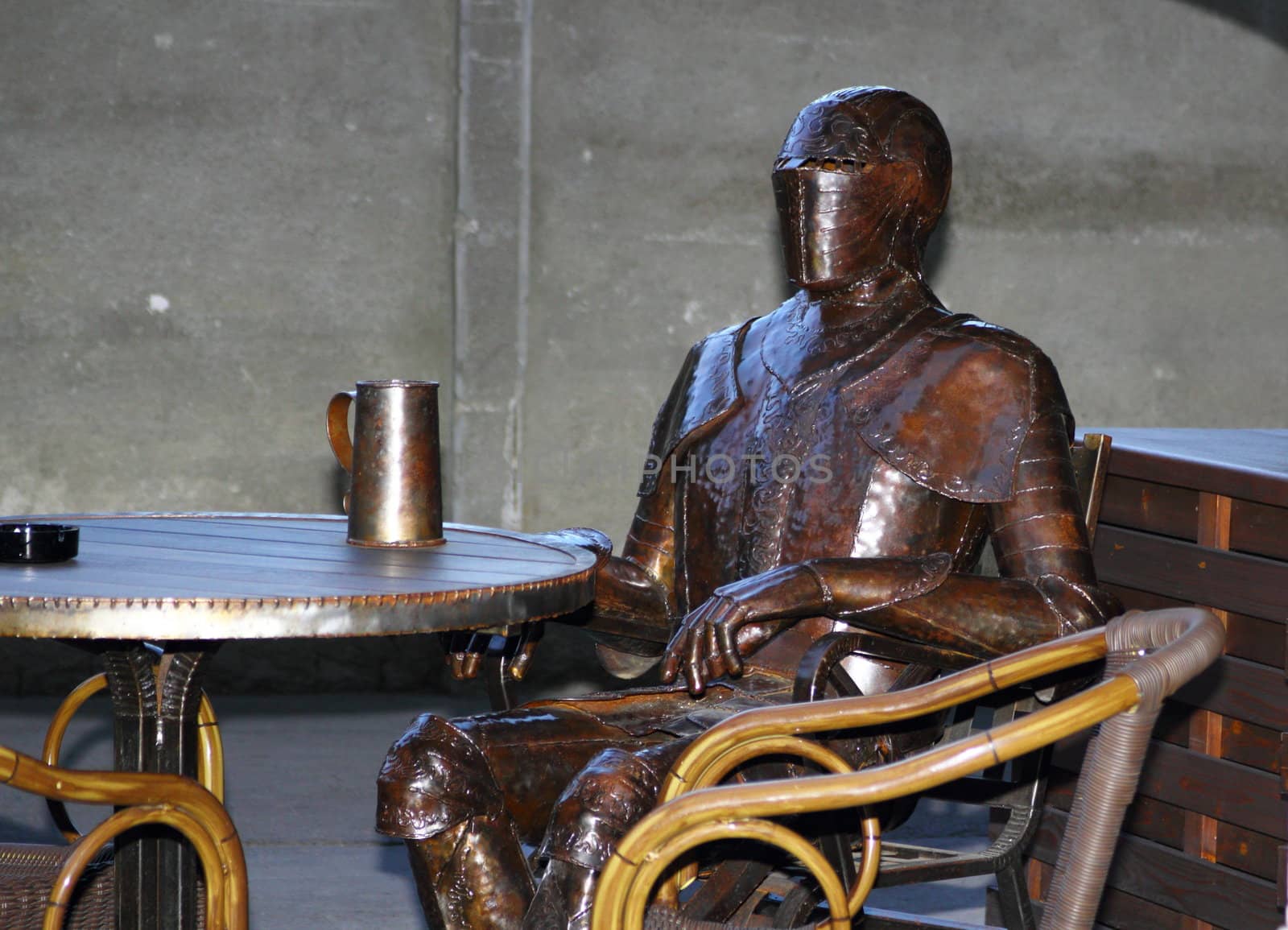 armour having a beer from a metal beer mug on a terrace