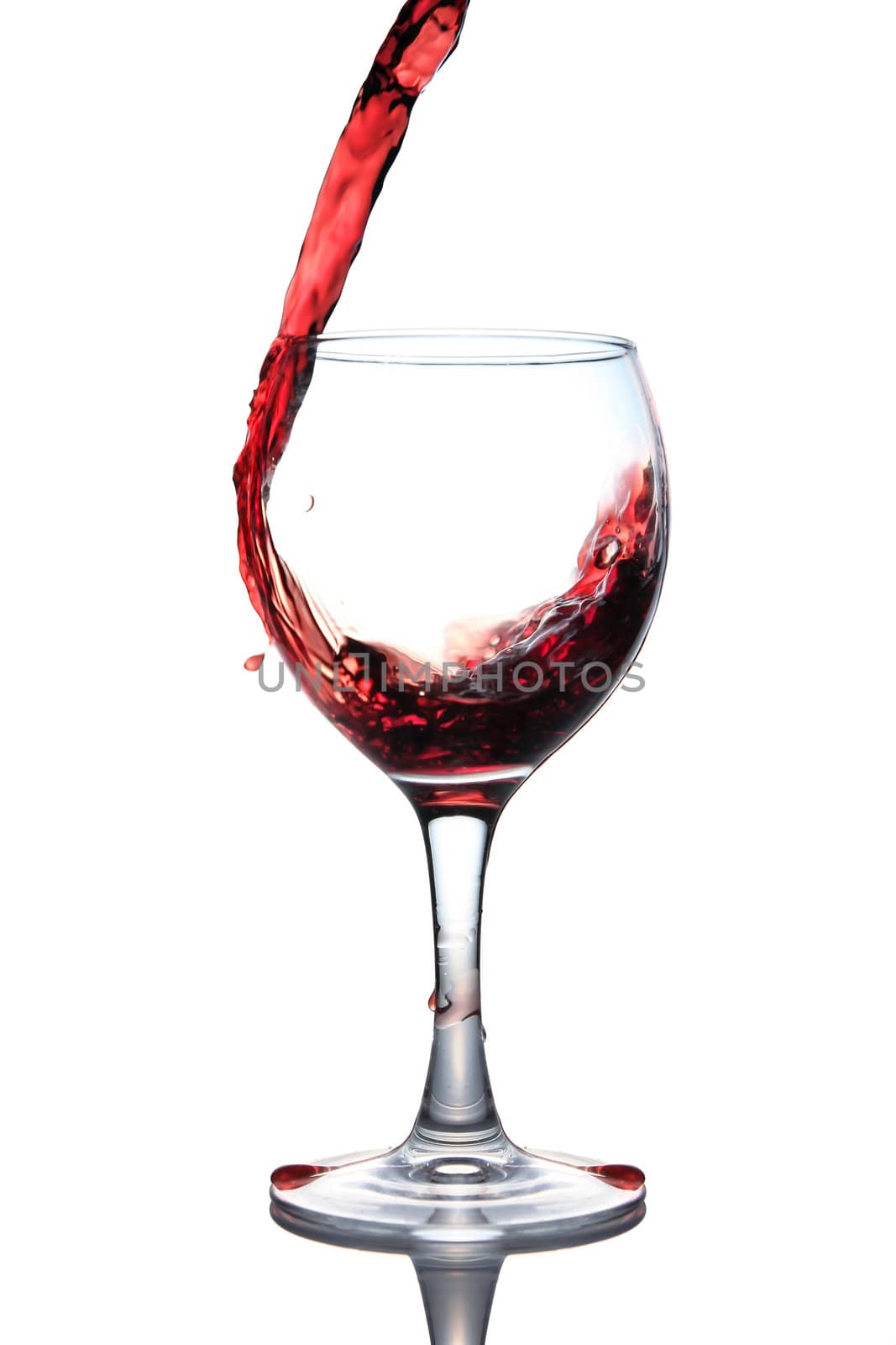 red wine pouring into glass isolated on white background 
