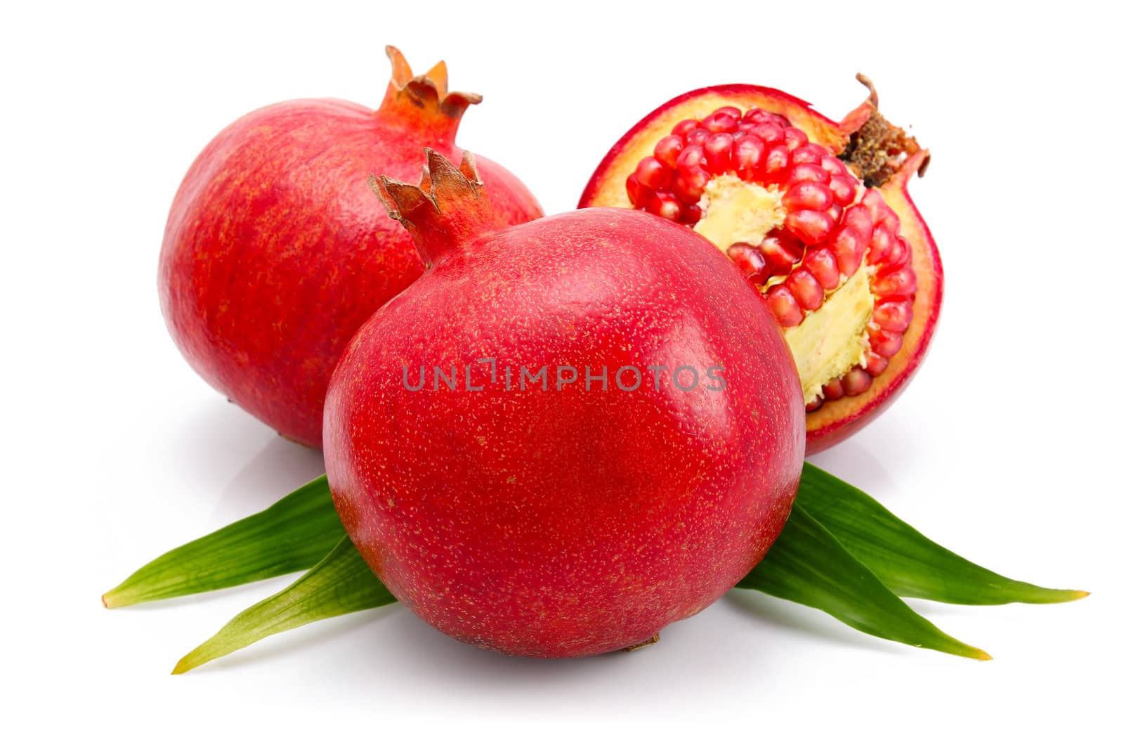 pomegranate fruits with green leaf and cuts isolated by alphacell