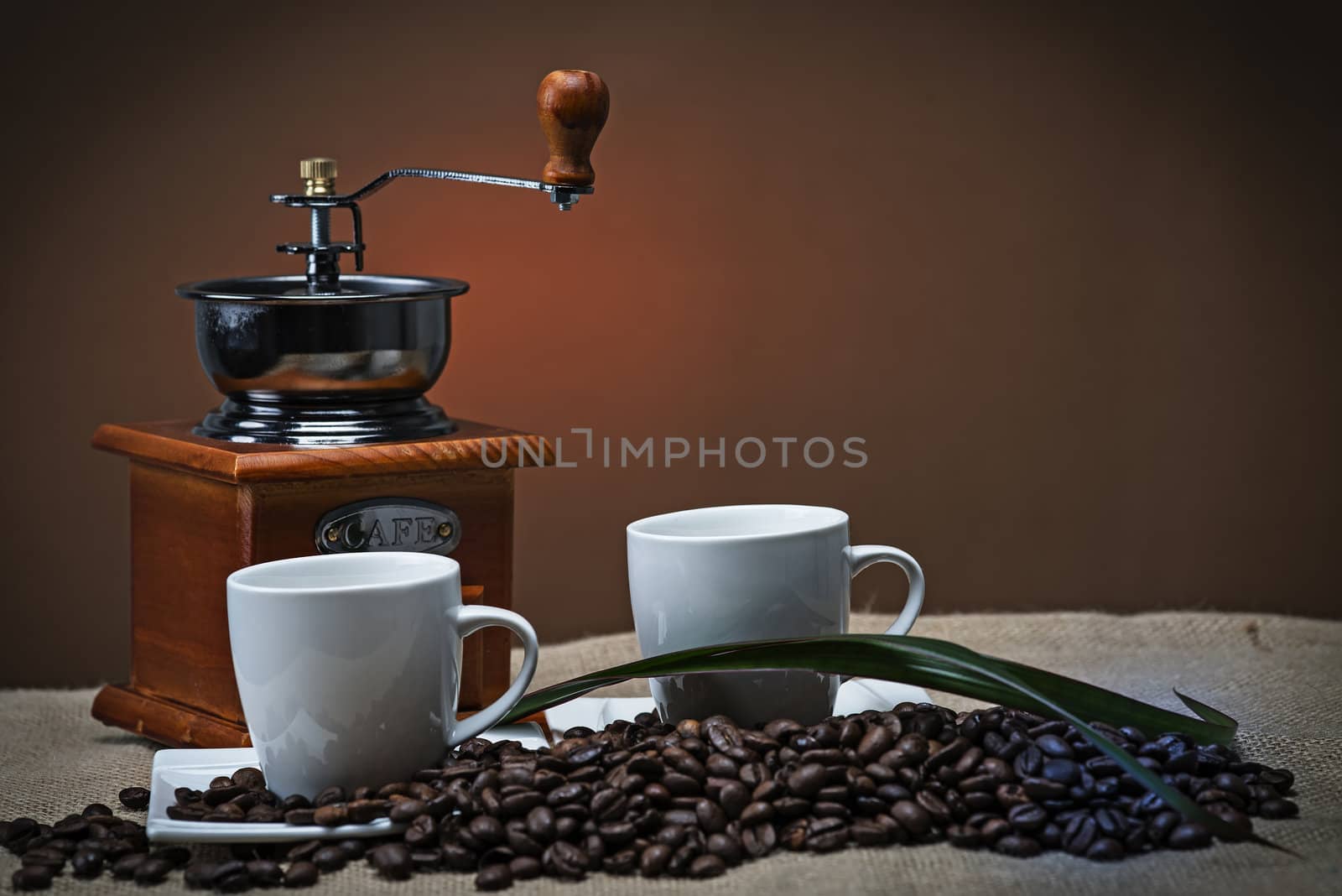 Still life about coffee with cups, beans and a mill