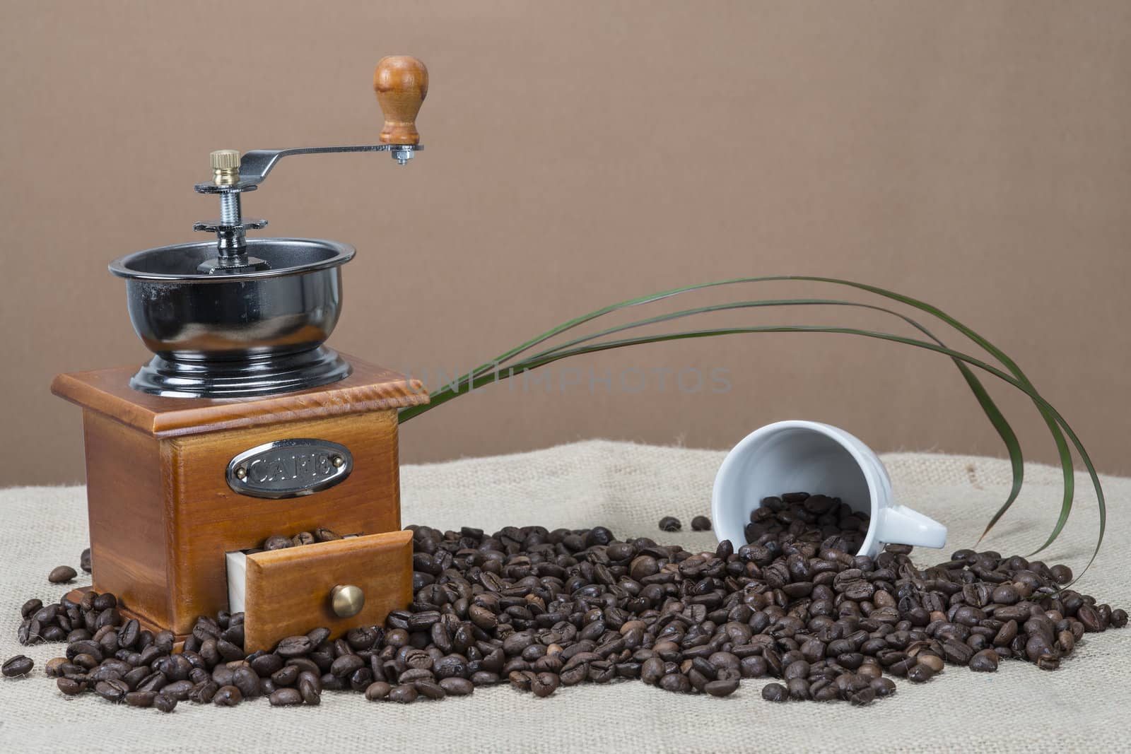 Coffee grinder and cups on some bean by angelsimon